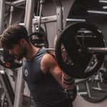 Man exercising with bar at gym